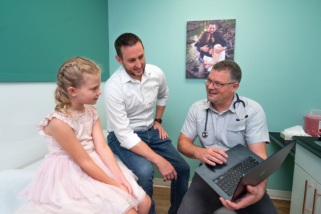 A Here We Grow pediatrician talking with a family in the exam room